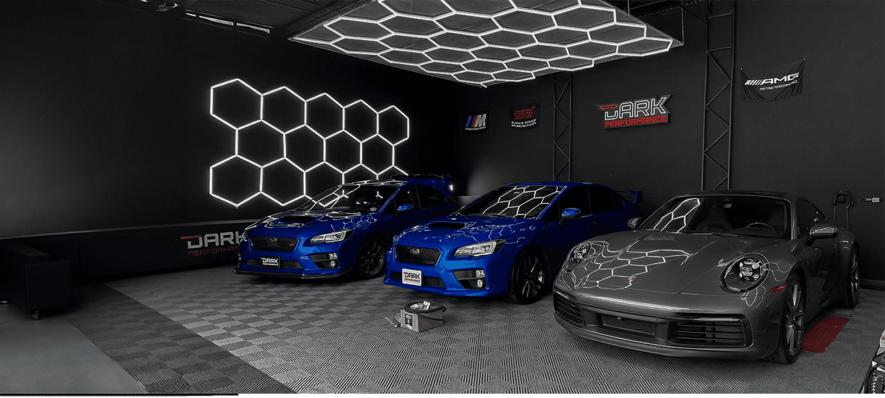 Taller Dark Performance con Subaru WRX azul y Porsche 911 gris