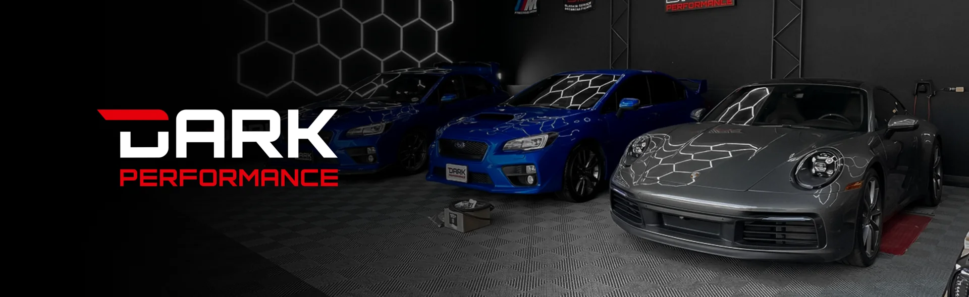 Taller Dark Performance con Subaru WRX azul y Porsche 911 gris